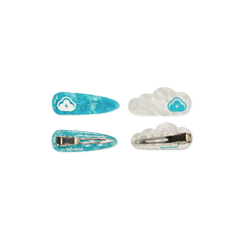 Four hair clips. First pair of shiny flecked blue hair pins with white dearcloud cloud image, one pin showing design in front, second pin showing the back metal clip. Second pair of shiny flecked white cloud shaped hair pinks with same blue dearcloud cloud image, one pin showing design in front, second pin showing the back metal clip. 