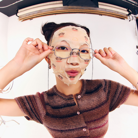 Model wearing a dearcloud face mask Face Mask inside is yellow with a monkey pattern.