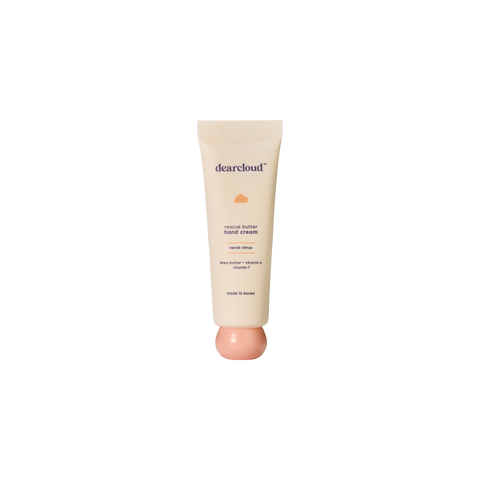 Beige tube of dearcloud Rescue Butter Hand Cream with a spherical pastel orange twist-off cap, featuring text indicating "neroli citrus," "shea butter," "vitamin E," and "vitamin F."