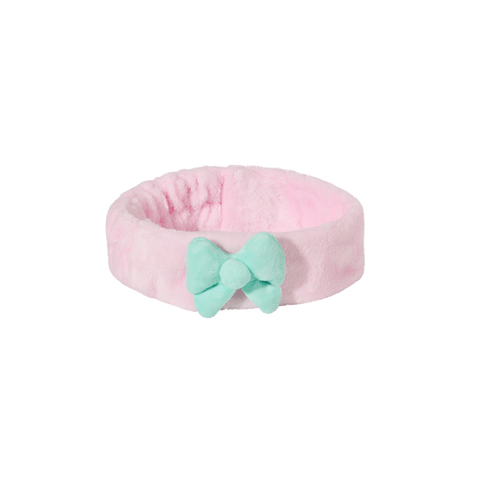 A pink and turquoise bow elegantly placed on a pink headband, showcasing a vibrant and stylish accessory.