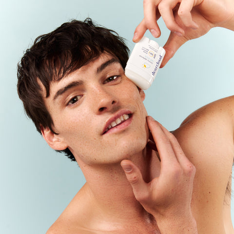 Male model applying SPF sun stick to cheek