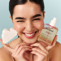 Model holding cleansing oil bottle to face