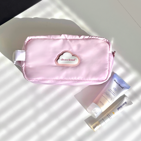 Cosmetic bag in Darling Pink style on flat surface with Vita-C Aqua Face Cream and Energy Bright Eye Serum