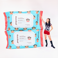 Model leaning on two very large makeup wipe packs that have a monkey pattern design and a blue background and red sides. 