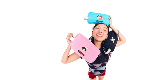 Model holding three Paul Frank Cosmetics Bags: Julius Teal, Bunny Girl Pink, and Skurvy Black.