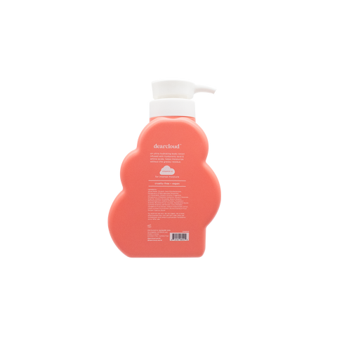 Back of peach-colored bottle of dearcloud Daily Repair Body Cream with a  white pump dispenser.