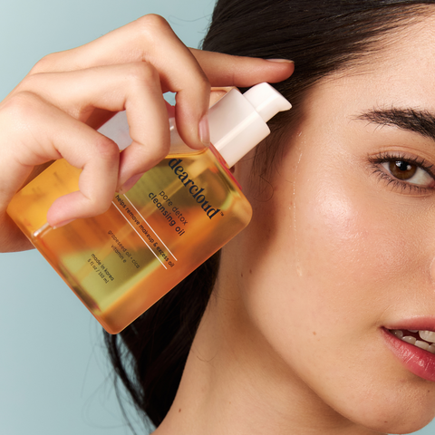 Model holding pore detox cleansing oil dripping down her face