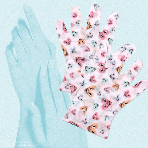 A pair of colorful exfoliating gloves with a playful Keith Haring heart pattern.