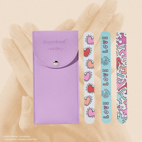 A set of three nail files with colorful Keith Haring-inspired designs, packaged in a small purple pouch.