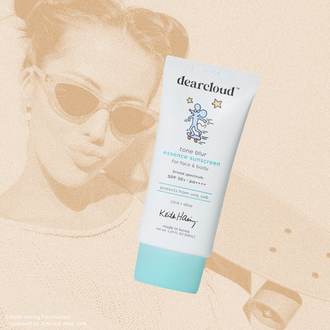 A tube of dearcloud Tone Blur Essence Sunscreen with a playful Keith Haring design, featuring an illustration of a cute mouse on a skateboard.