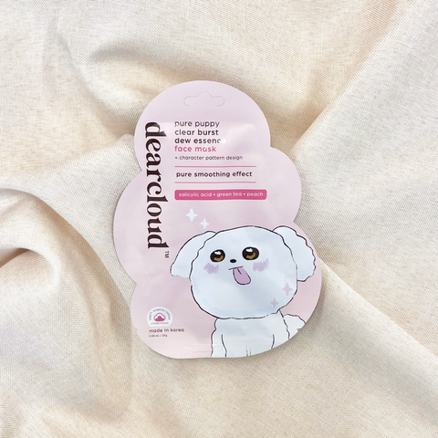 Dearcloud Pure Puppy Clear Burst Dew Essence Face Mask with a light pink background and a playful puppy design. Cloud-shaped packaging. Bichon puppy illustration. Pouch is on a taupe linen fabric.